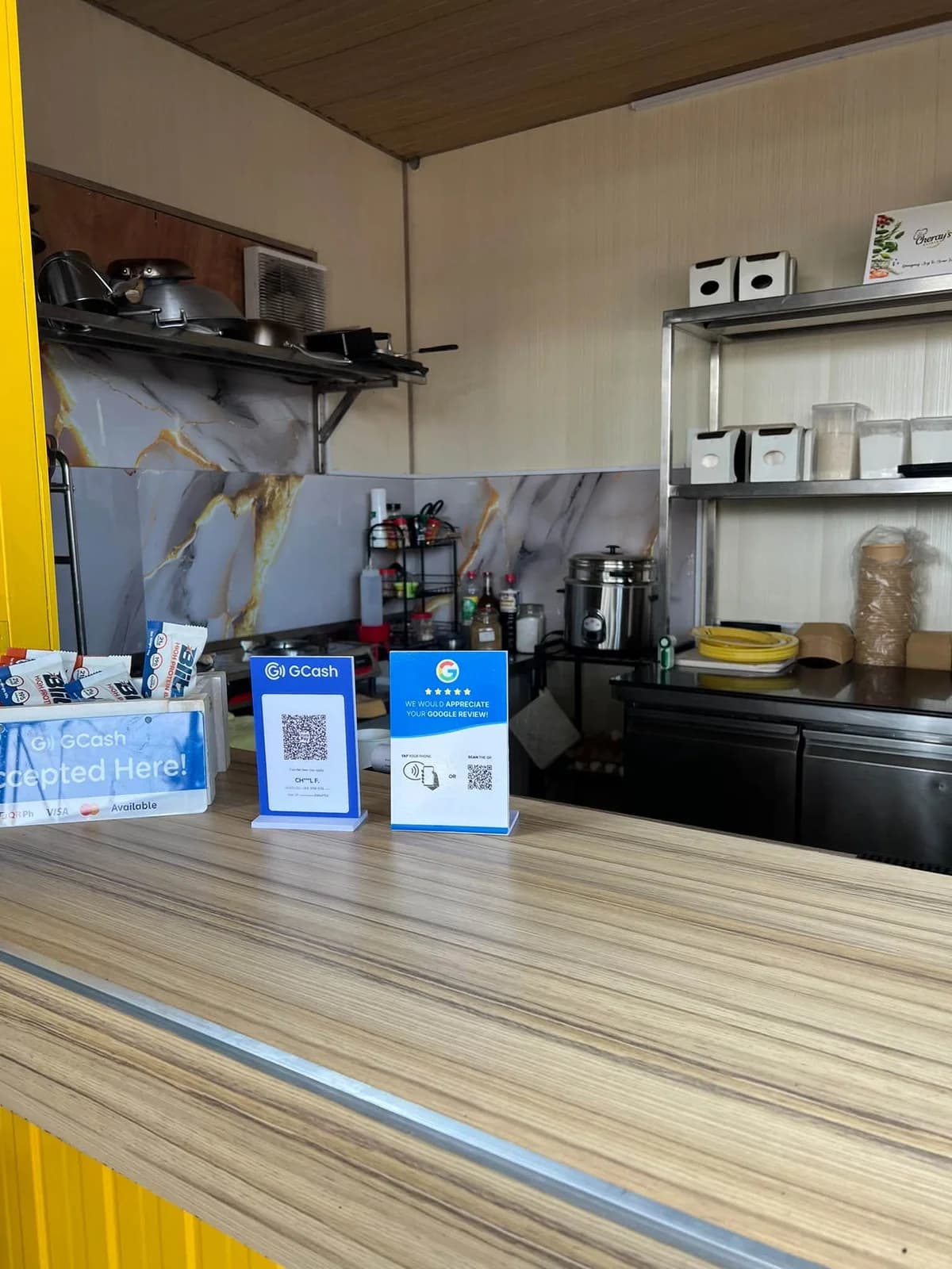 A Goreview stand next to a GCash sign on a food shop counter.